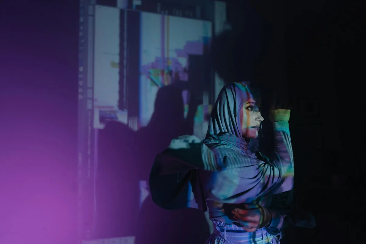 Retrato vibrante de mujer con hiyab y proyecciones de luz artísticas