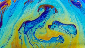 Bright and colorful abstract liquid paint texture with flowing patterns and vibrant hues.