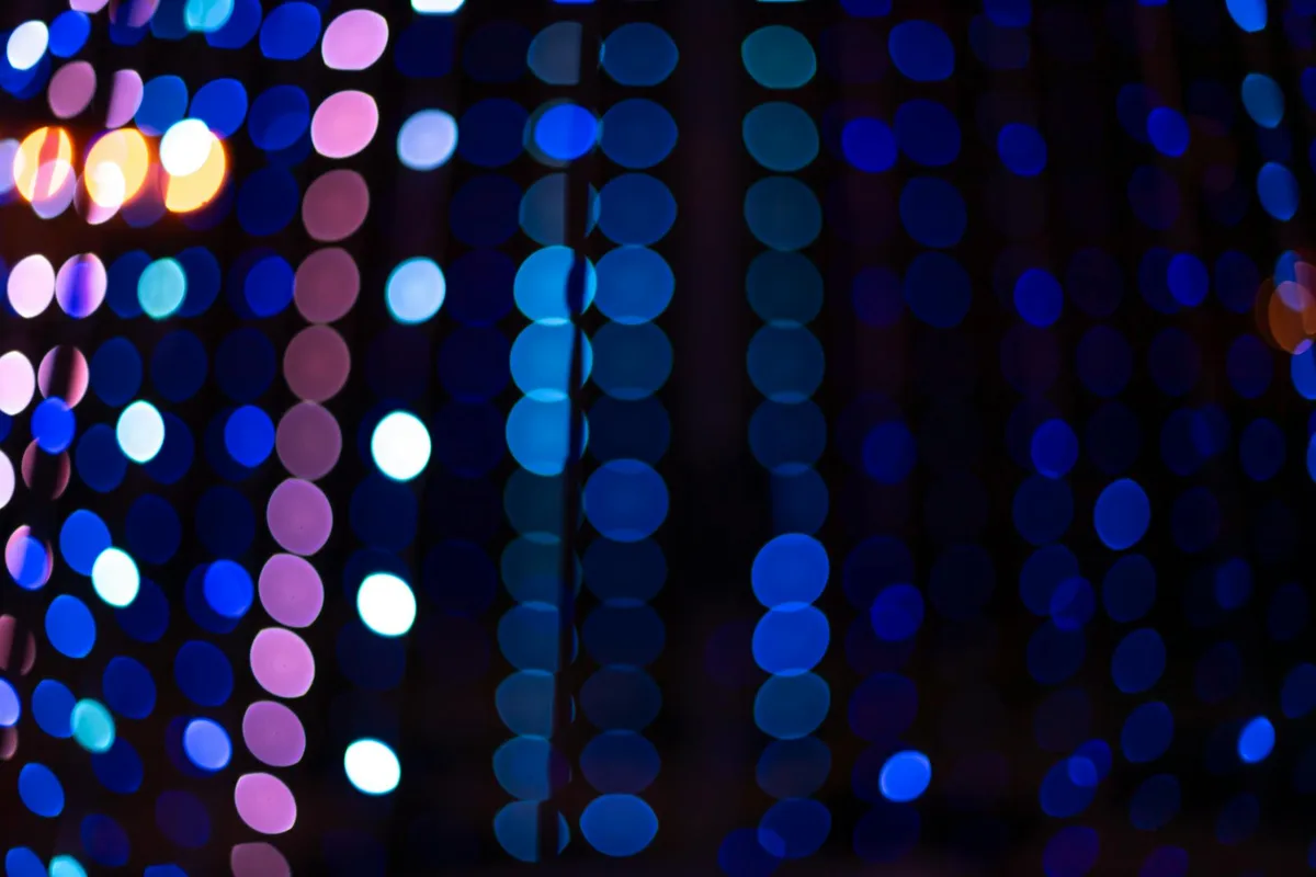 Bokeh colorato e vibrante di luci festive che crea sfondo caldo e sfocato.