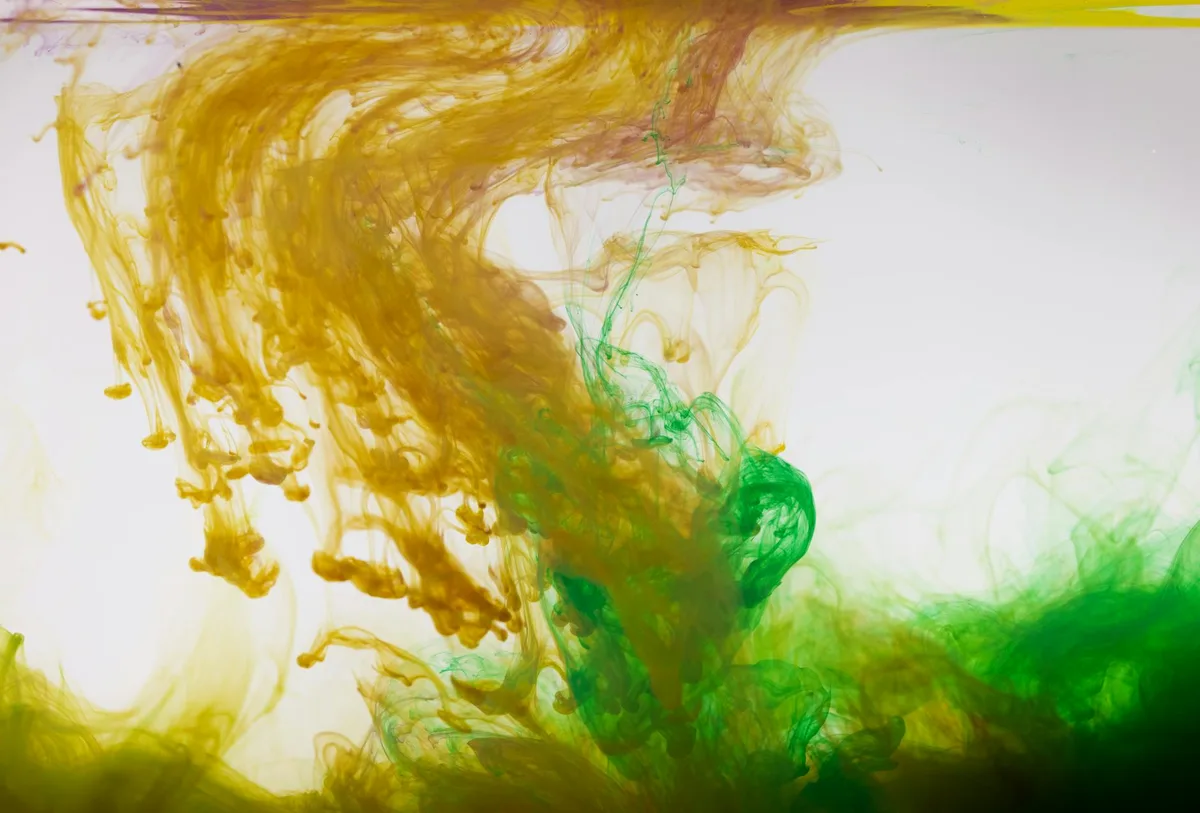 Arte astratta dinamica con inchiostro giallo e verde vorticoso sott'acqua
