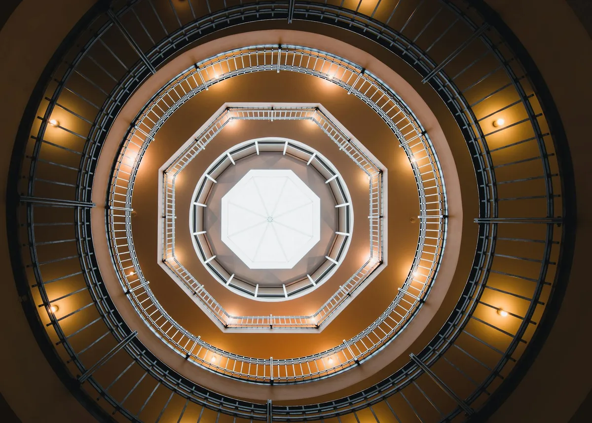 Elegante Wendeltreppe von unten in einem Hamburger Gebäude mit architektonischer Geometrie