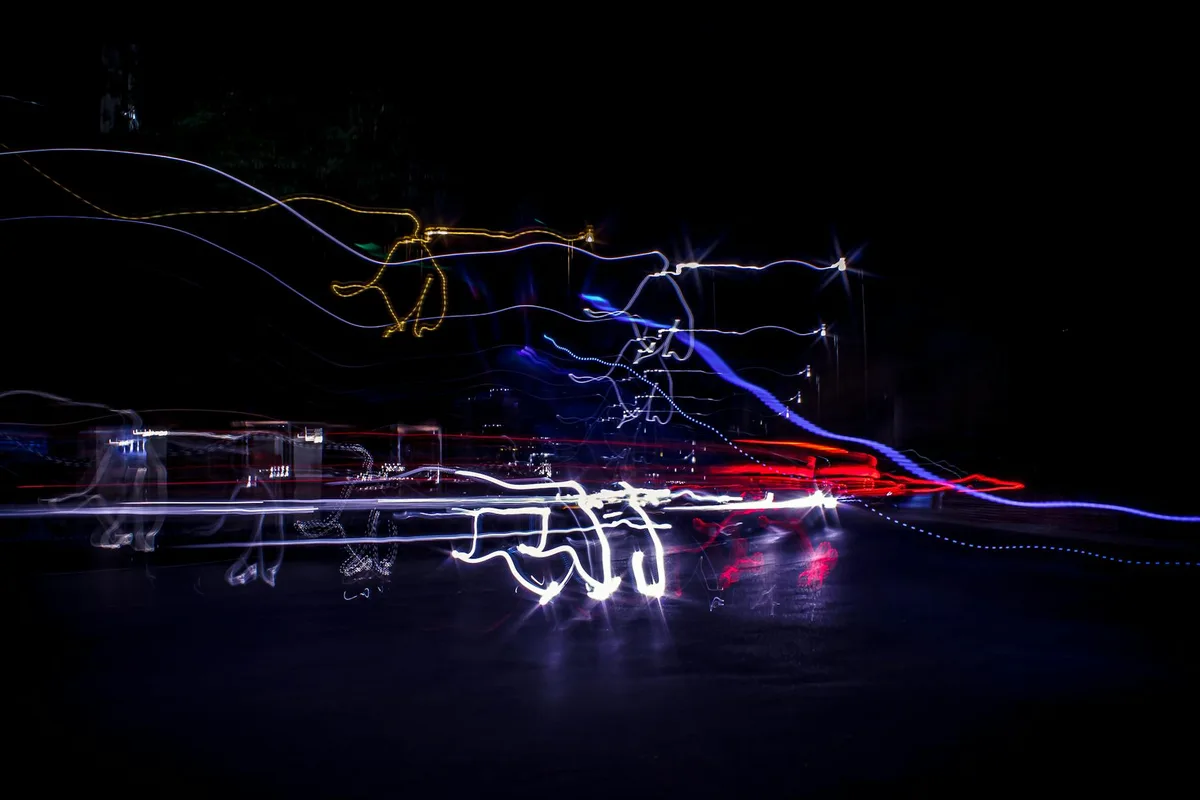 Lunga esposizione di tracce luminose vibranti in scenario urbano notturno