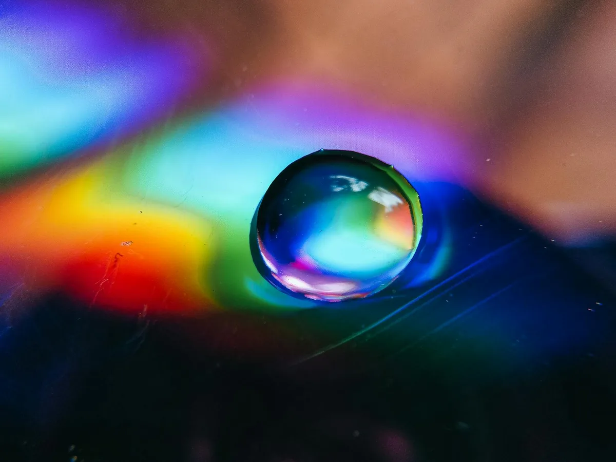 Vibrante macro di goccia d'acqua con rifrazione arcobaleno
