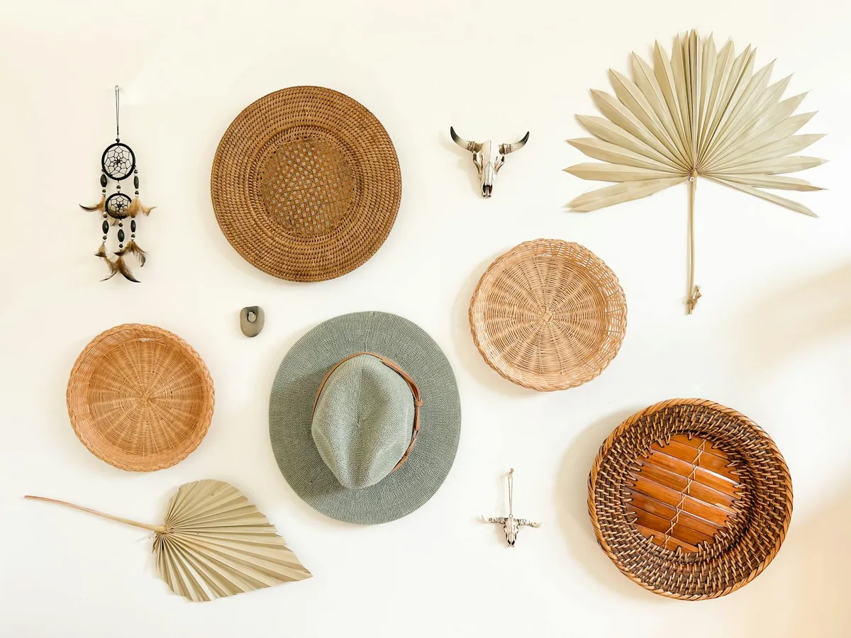Boho-Wanddeko mit Strohkörben, Hüten, Traumfänger und Dekorationsobjekten