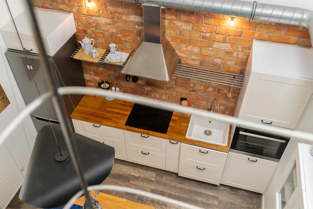 Moderne Küche mit Backsteinmauer und Holztheke mit modernen Geräten