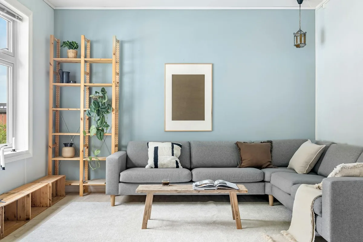 모던 그레이 소파와 우드 요소가 있는 스칸디나비안 스타일의 아늑한 거실