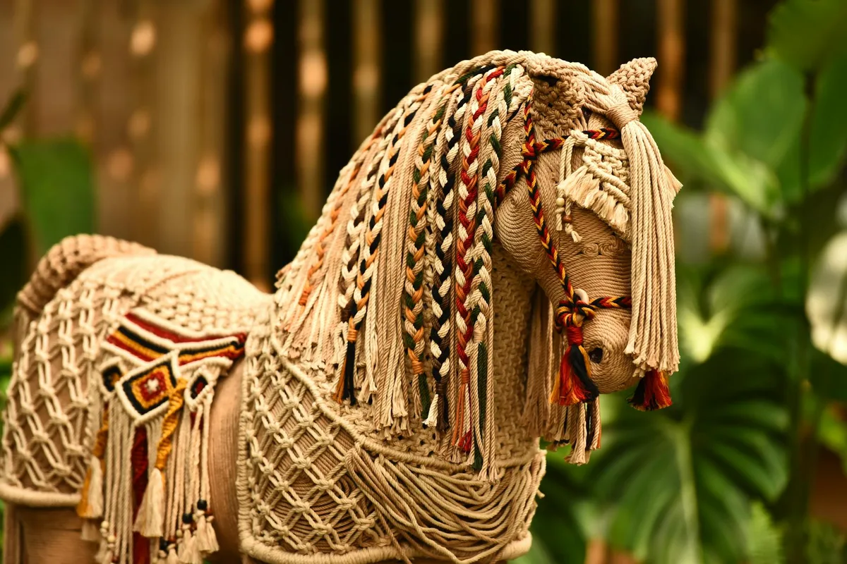 Makramee-Pferdeskulptur mit komplexen Flechtmustern vor Naturhintergrund