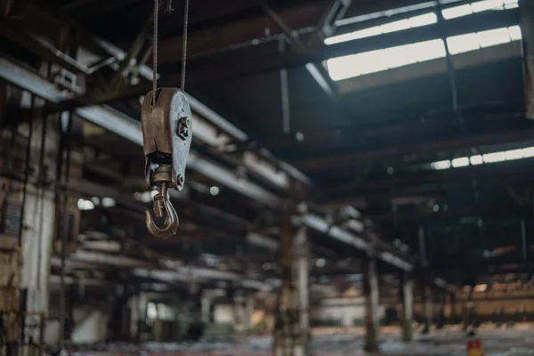 Gancio metallico industriale appeso in un magazzino rustico