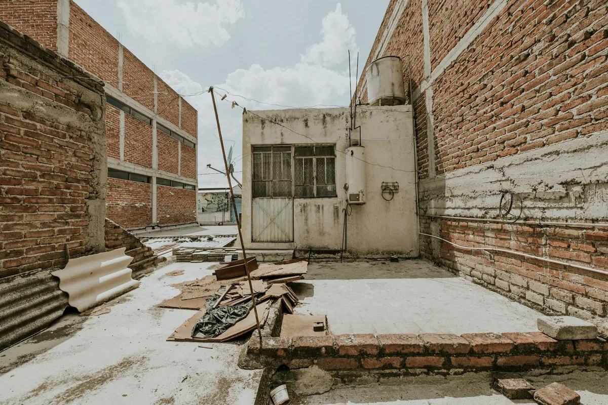 Verfallenes Stadtlagerhaus mit roten Backsteinmauern und Schutt, urbaner Verfall