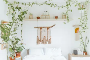 A serene bedroom adorned with hanging plants, minimalist decor, and a cozy ambiance.