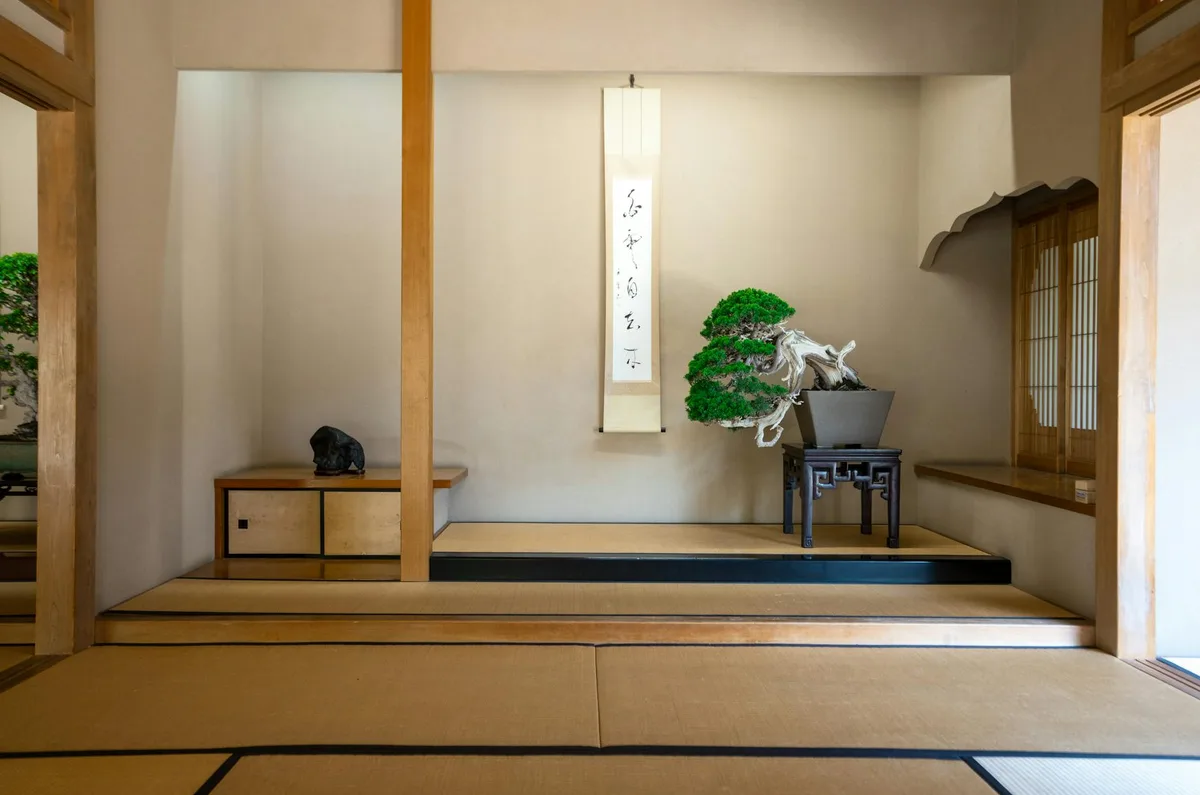 Habitación japonesa serena con bonsái y pergamino de caligrafía, estética zen