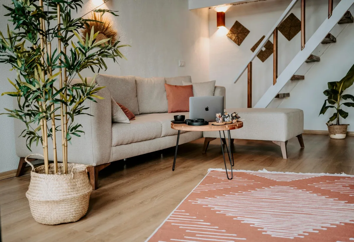 Soggiorno elegante con divano, tavolino in legno e piante da interno