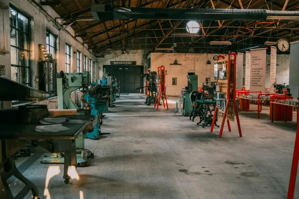 Officina industriale spaziosa con macchinari d'epoca e attrezzi sotto tetto in legno