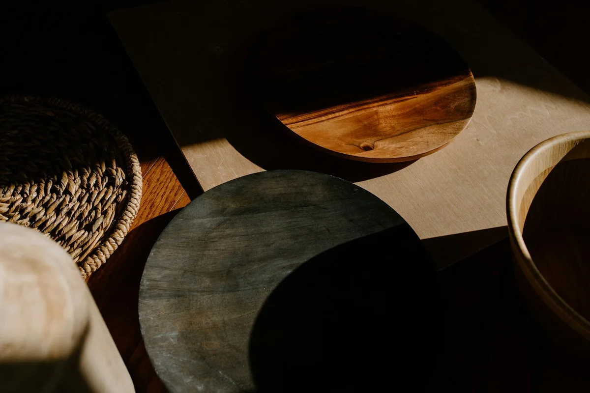 Disposición artística de cuencos de madera con sombras y textura en entorno minimalista
