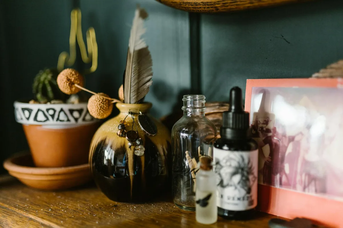 Künstlerisches Stillleben mit Glasflaschen, Dekovase und Bilderrahmen auf Holzregal