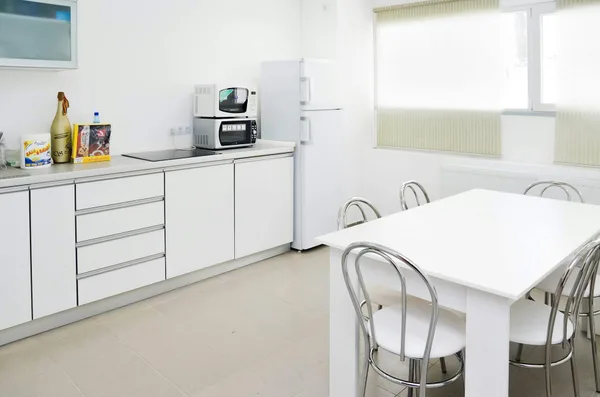 Helle, weiße Küche mit eleganten Möbeln und modernen Geräten
