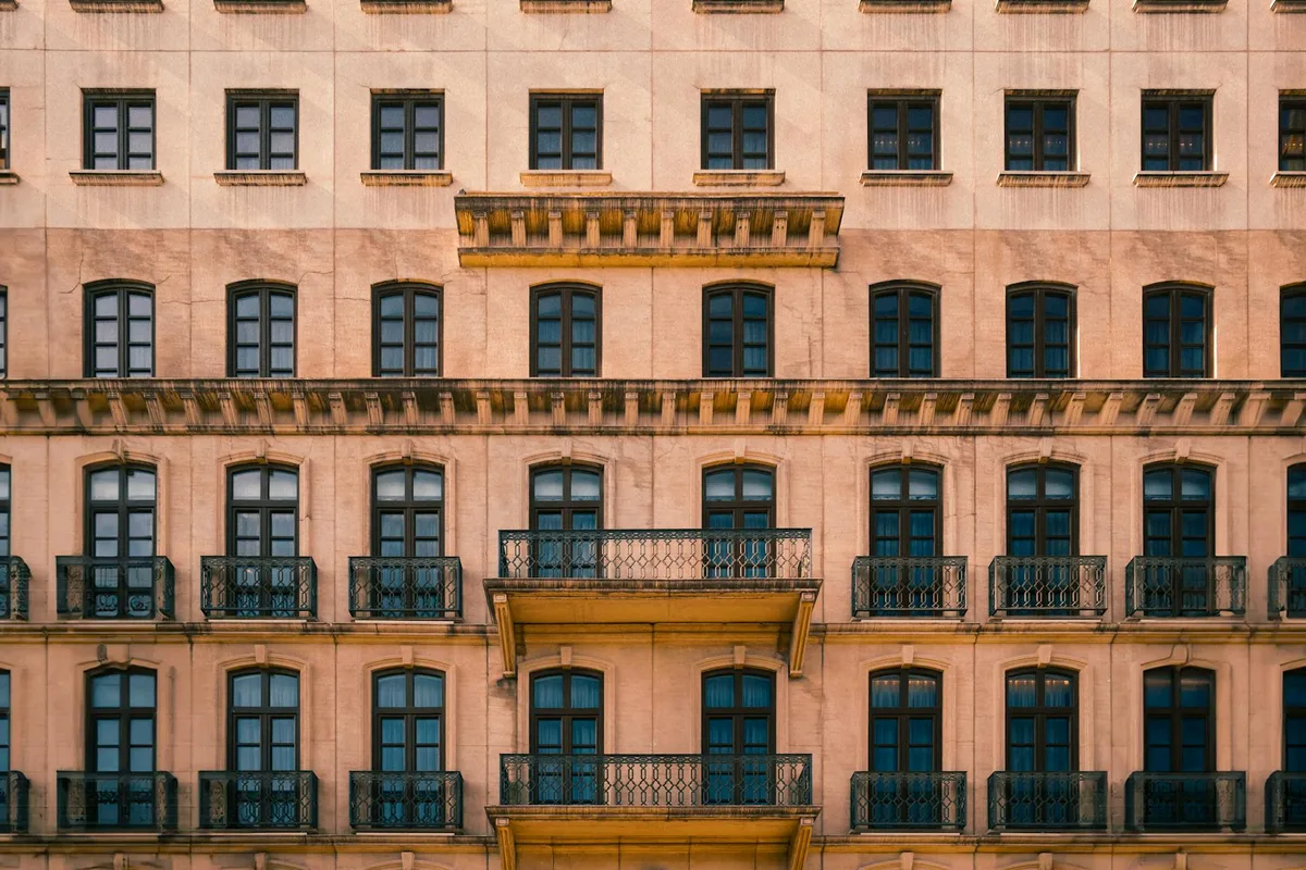 Klassische Gebäudefassade mit symmetrischem Design und Balkonen in warmen Beigetönen