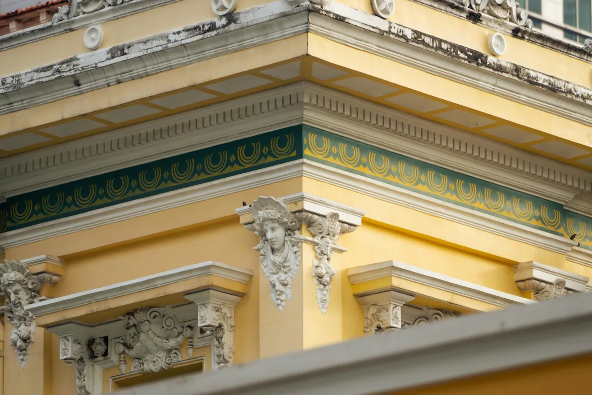 Primo piano di dettagli architettonici ornamentali su una facciata gialla classica al sole