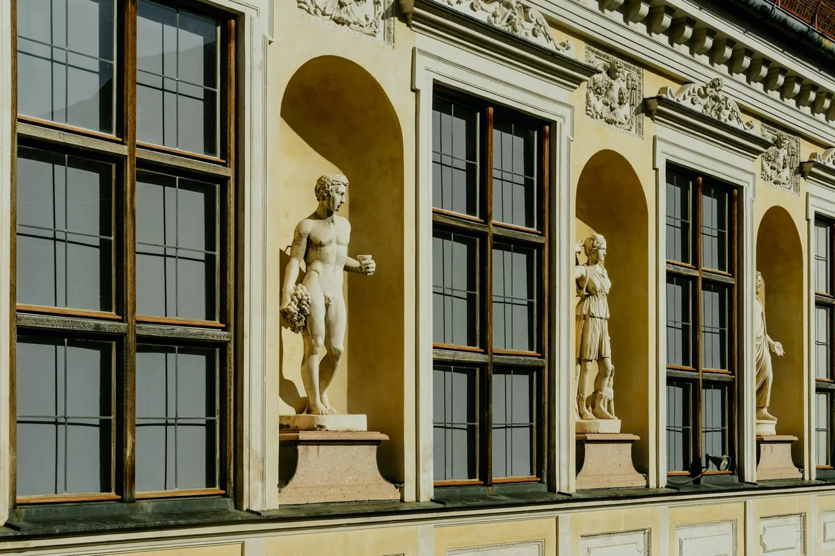 Vista dettagliata di facciata classica con statue ornate e grandi finestre