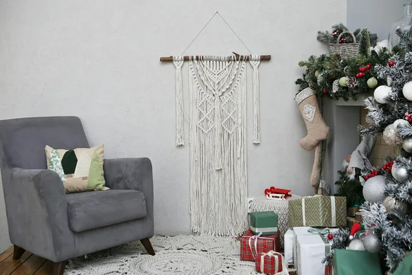 Elegant Christmas-themed Scandinavian interior with armchair, decor, and gifts.
