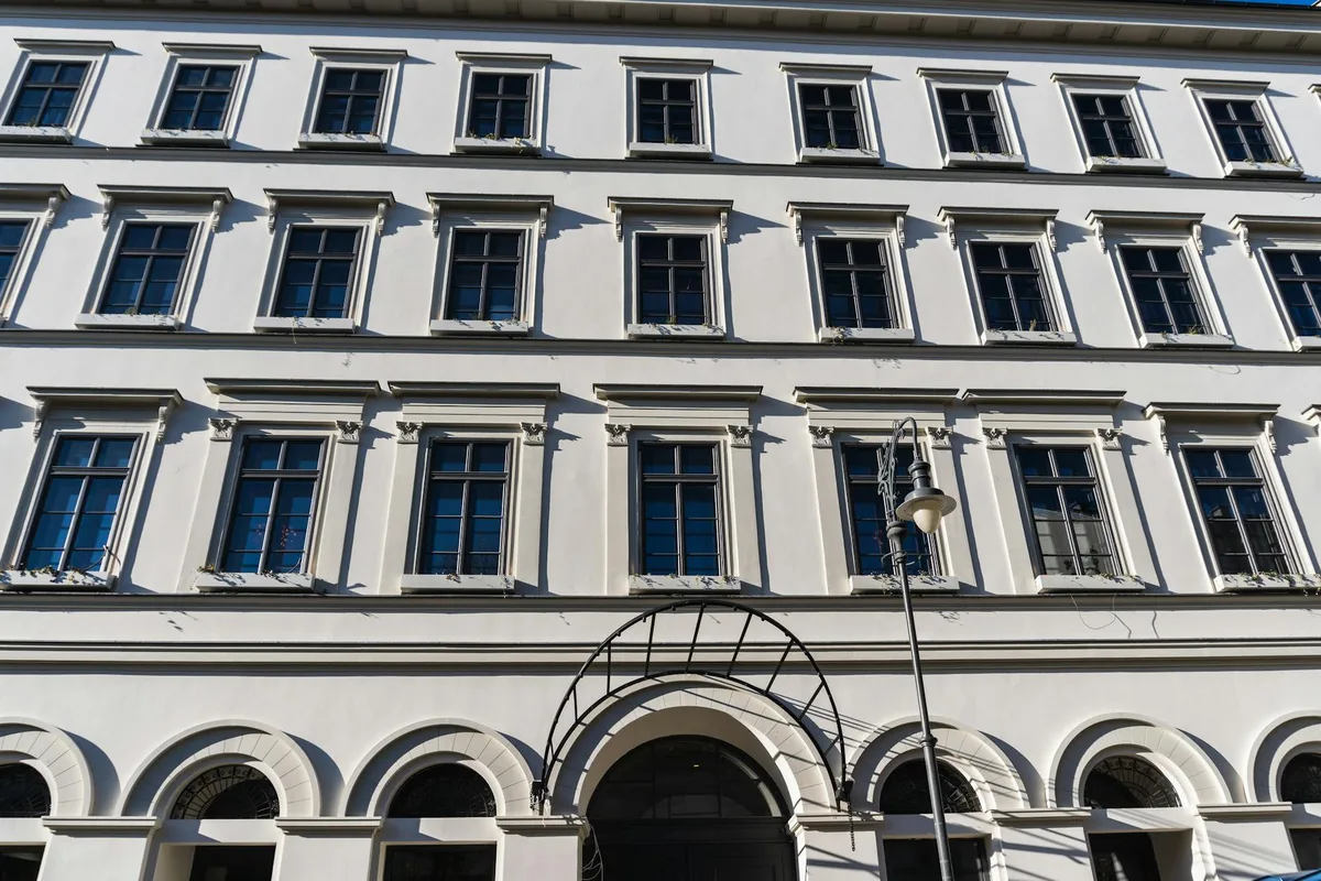 Façade élégante d'un immeuble européen aux fenêtres symétriques et détails classiques