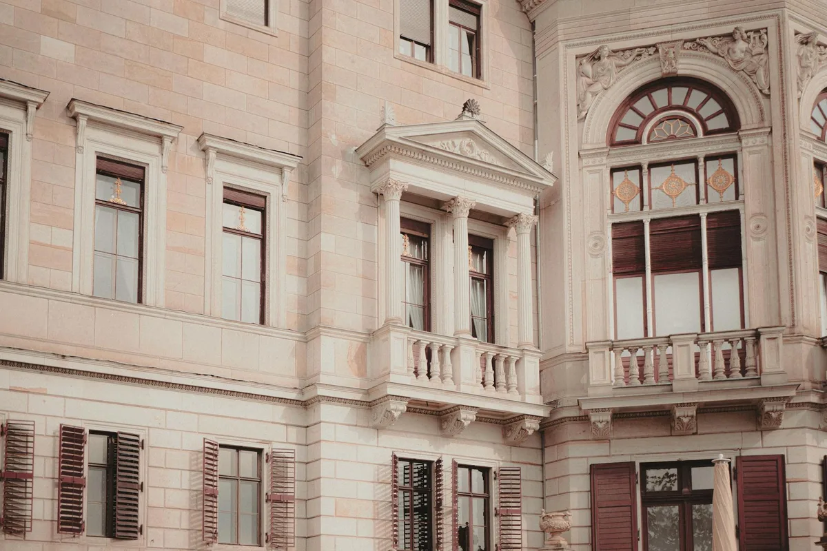 Elegante Fassade eines klassischen Gebäudes mit dekorativen Säulen und kunstvollen Fenstern