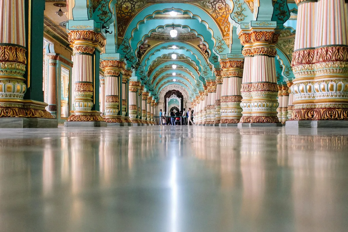Interior do Salão Durbar do Palácio de Mysore com arcos entalhados e colunas ornamentais