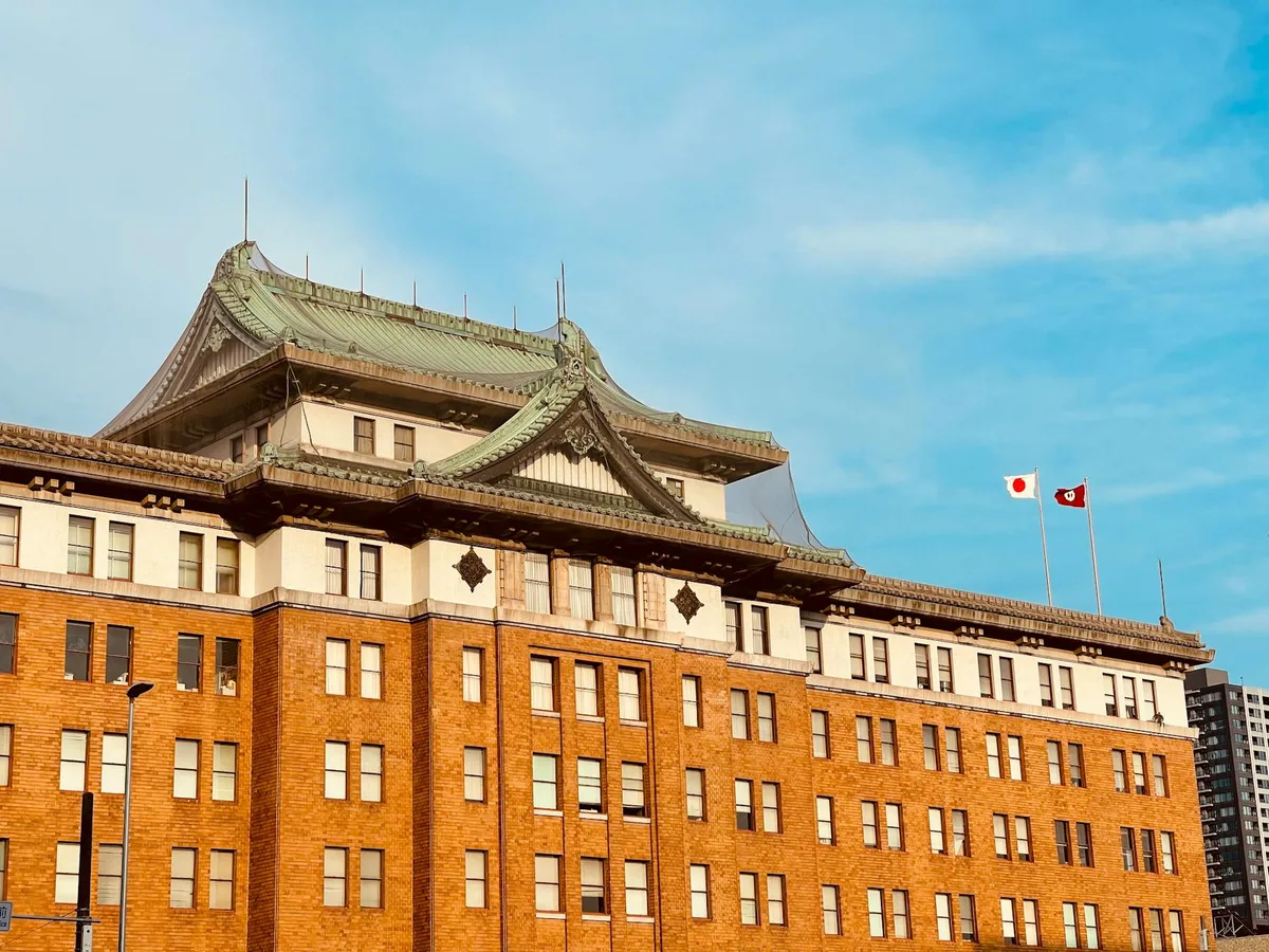 Historic government building facade in Nagoya showcasing imperial crown style architecture under a bright blue sky.
