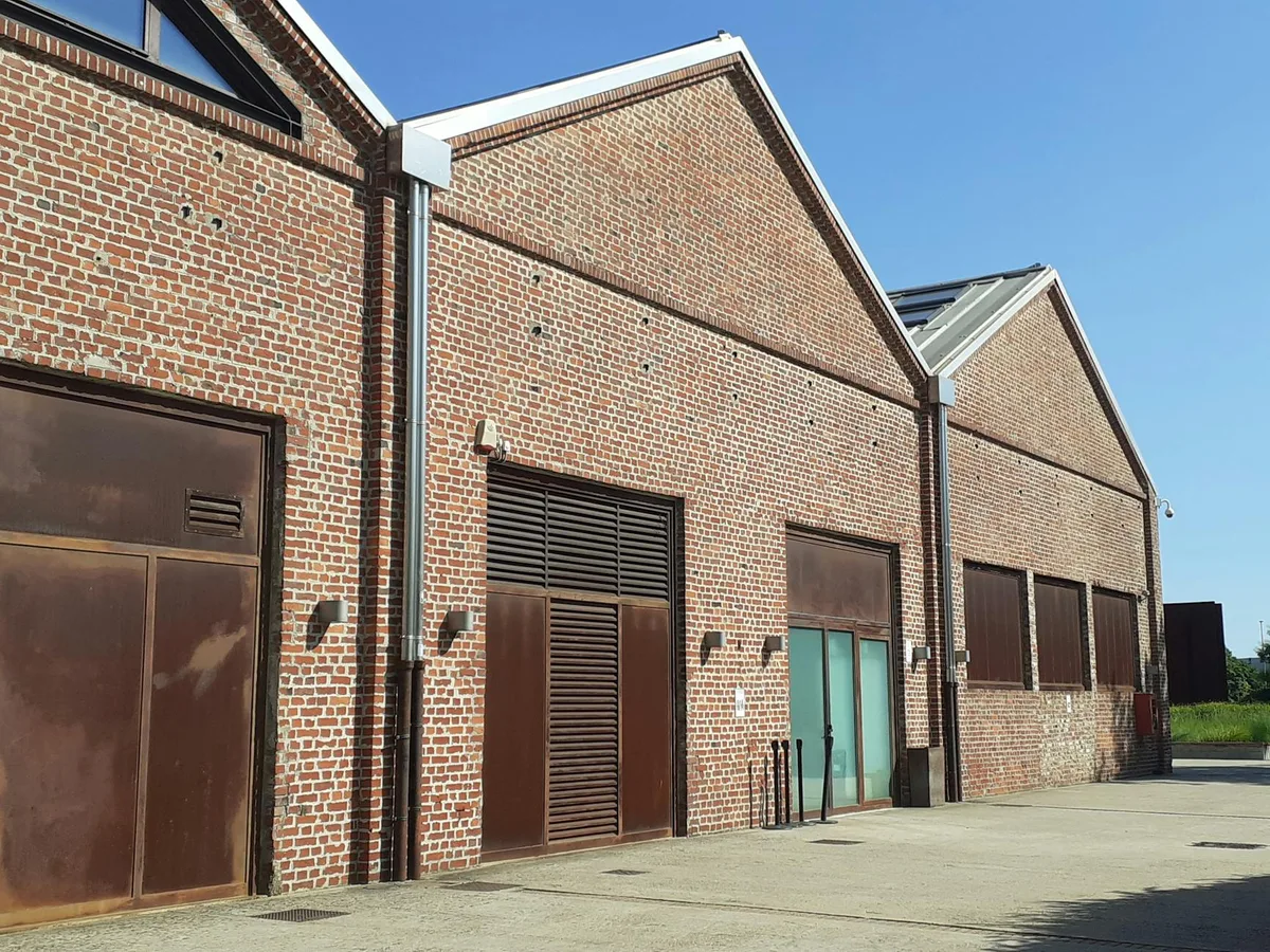 Industrie-Rotbacksteinlagerhäuser mit Holztüren bei Tageslicht, klarer Himmel