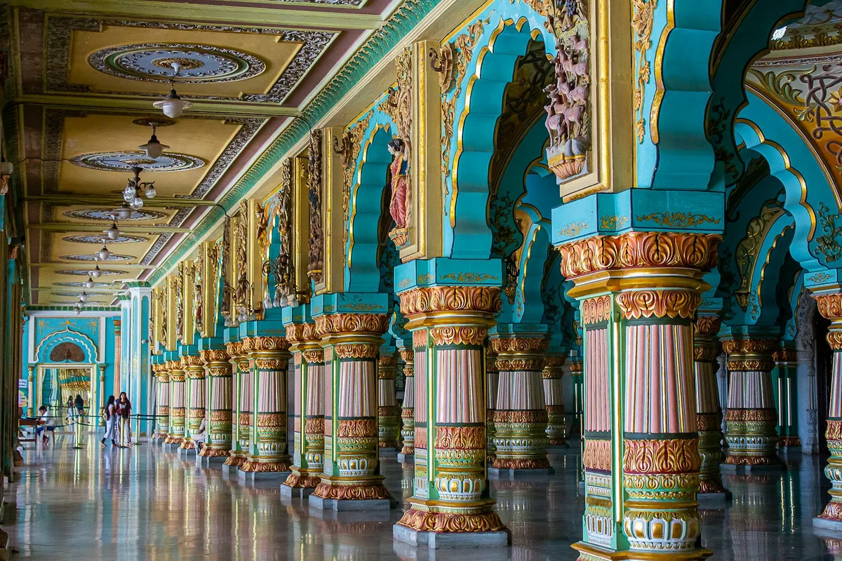 Ornamentale Säulen und lebendige Farben im prunkvollen Korridor des Mysore-Palastes, Indien