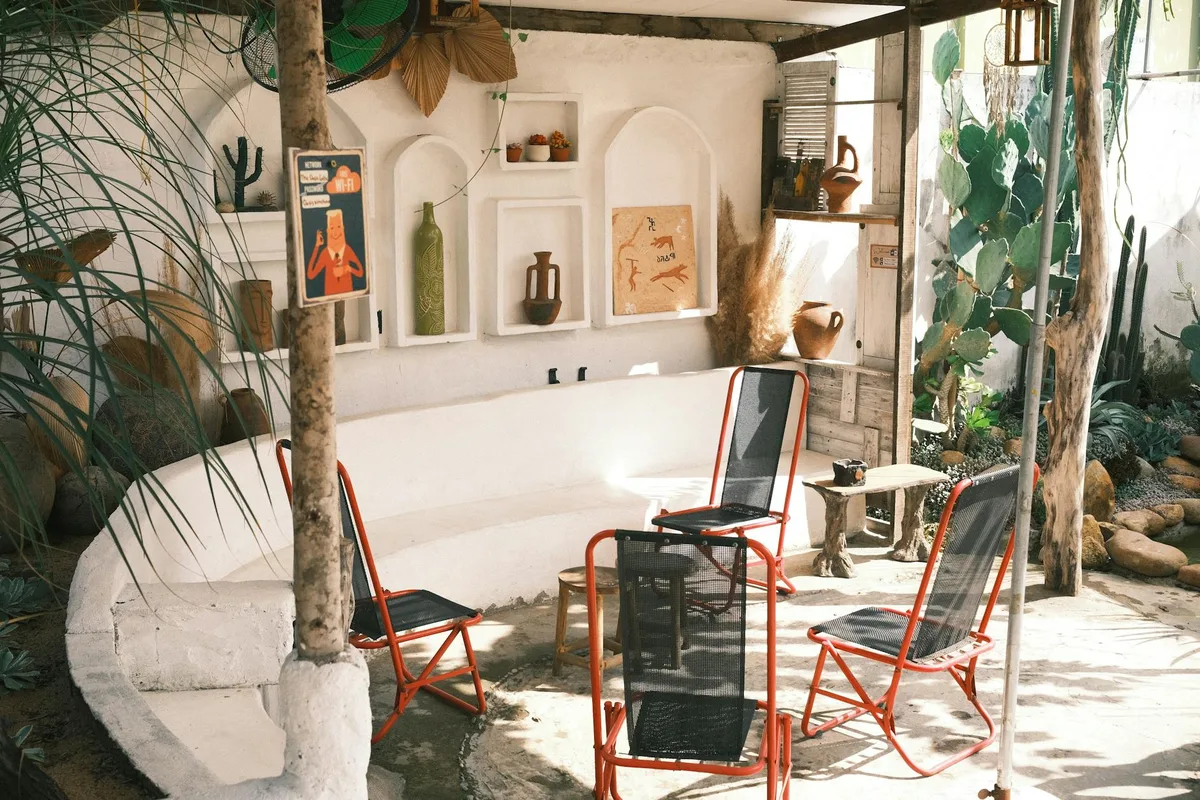 Patio accogliente con sedie rosse, cactus e toni terrosi per ambiente sereno e stiloso