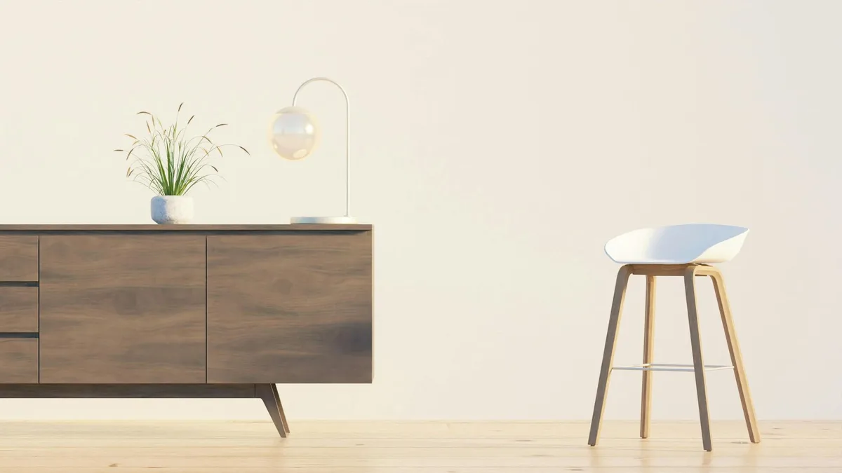 Interno minimalista con credenza, sedia, lampada e pianta su parete bianca