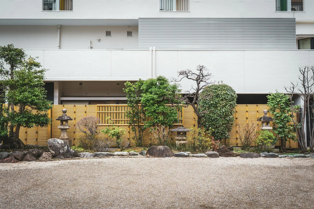 Cortile giapponese sereno con verde e lanterne di pietra a Tokyo