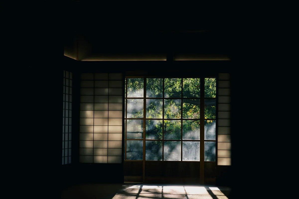 Ruhiges japanisches Interieur mit Shoji-Türen und Blick auf einen üppigen grünen Garten