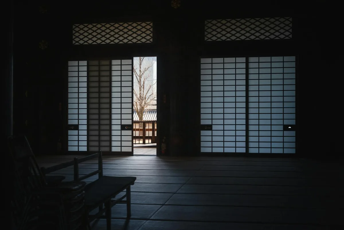 Vue sereine d'une pièce japonaise traditionnelle aux portes shoji entrouvertes à Kyoto
