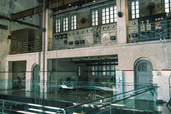 Interno industriale spazioso con macchinari vintage e passerella in vetro