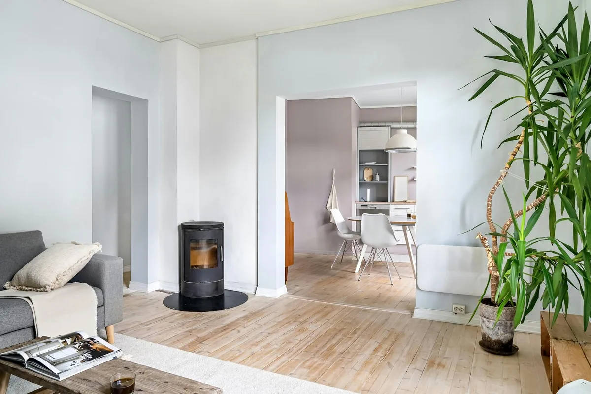 Stilvolles Interieur eines modernen Wohnzimmers mit Holzofen und Zimmerpflanze