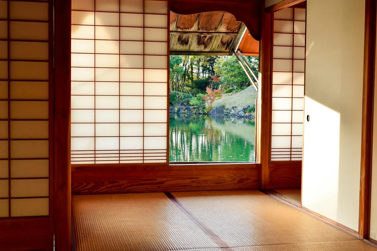 Traditionelles japanisches Zimmer mit Shoji-Schiebetüren und Blick auf ruhigen Gartenteich