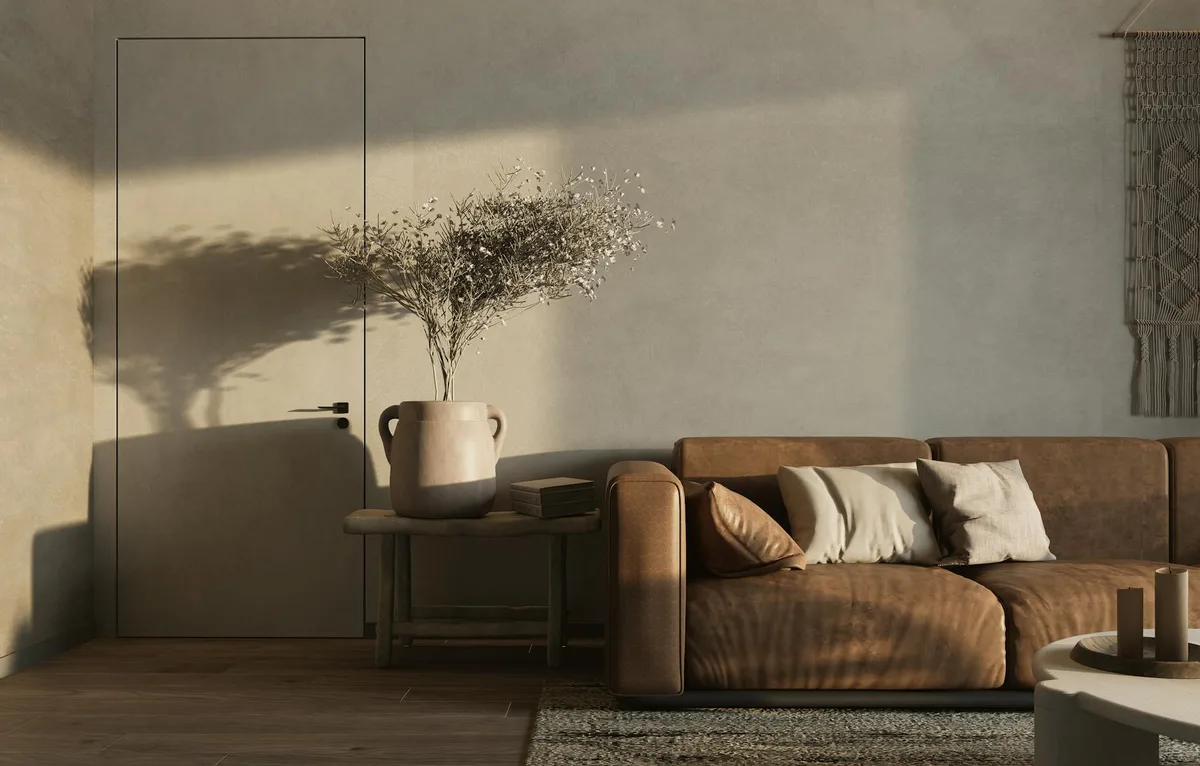 Warmes minimalistisches Wohnzimmer mit braunem Sofa und Dekoelementen