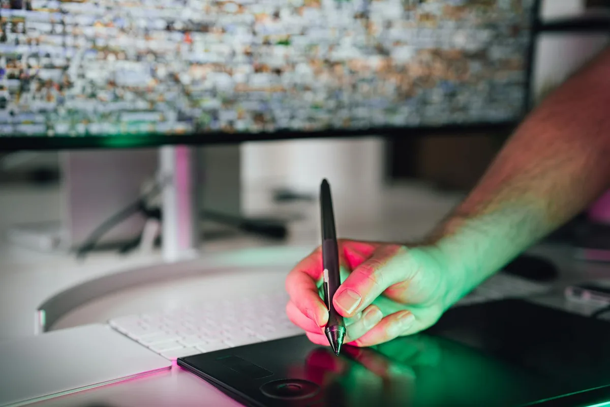 Artista digitale con tavoletta grafica e stilo in spazio di lavoro moderno