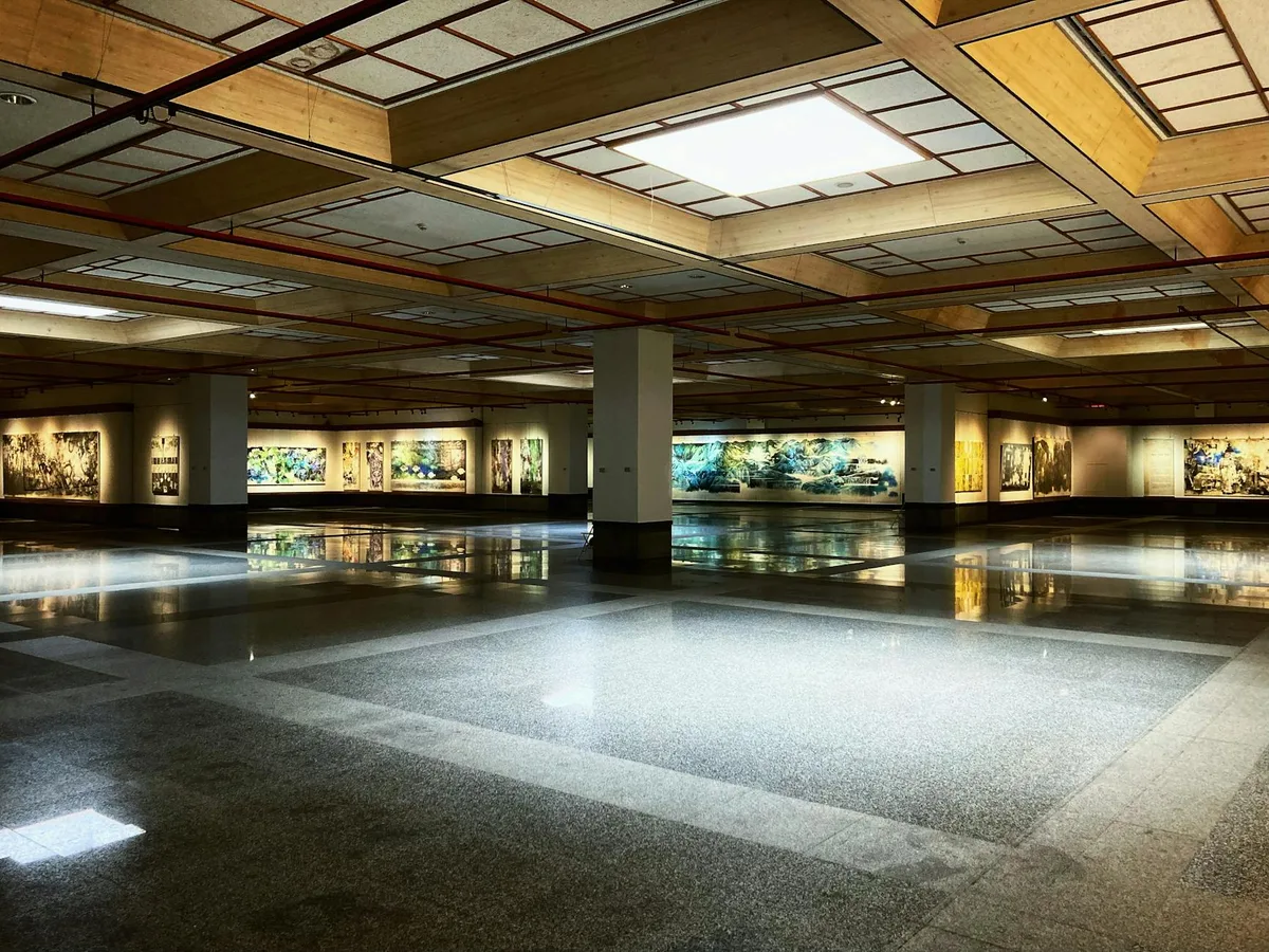 Galleria d'arte vuota con dipinti moderni sotto luce interna brillante