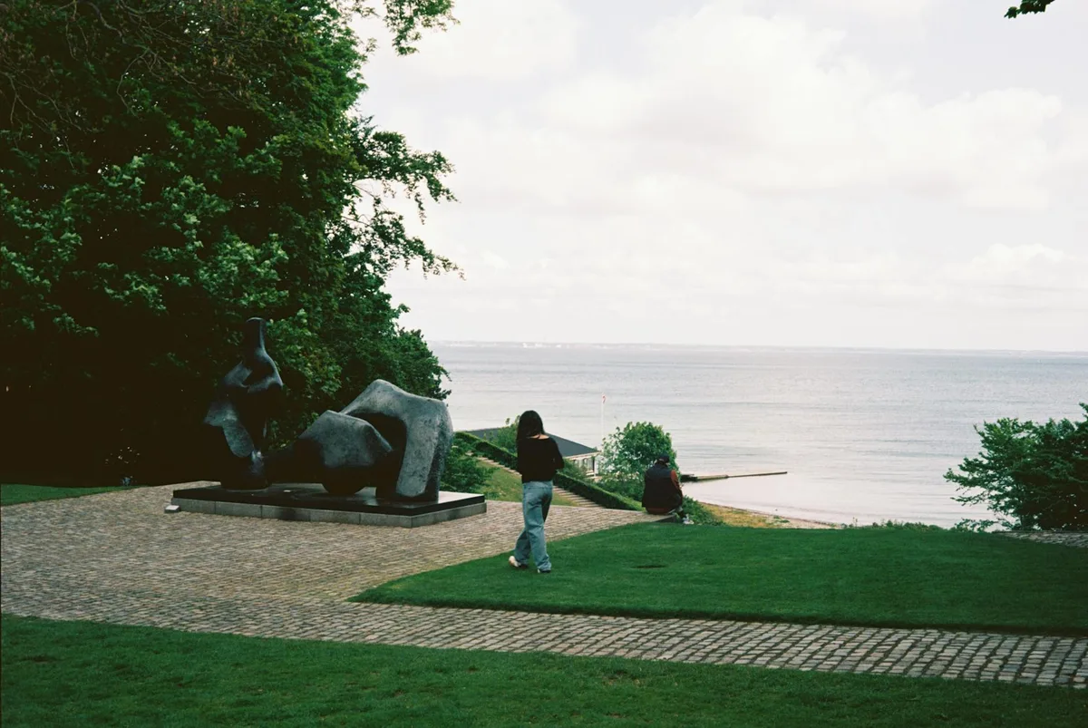 Friedlicher Spaziergang am Meer mit Skulpturen und üppigem Grün in Humlebaek, Dänemark