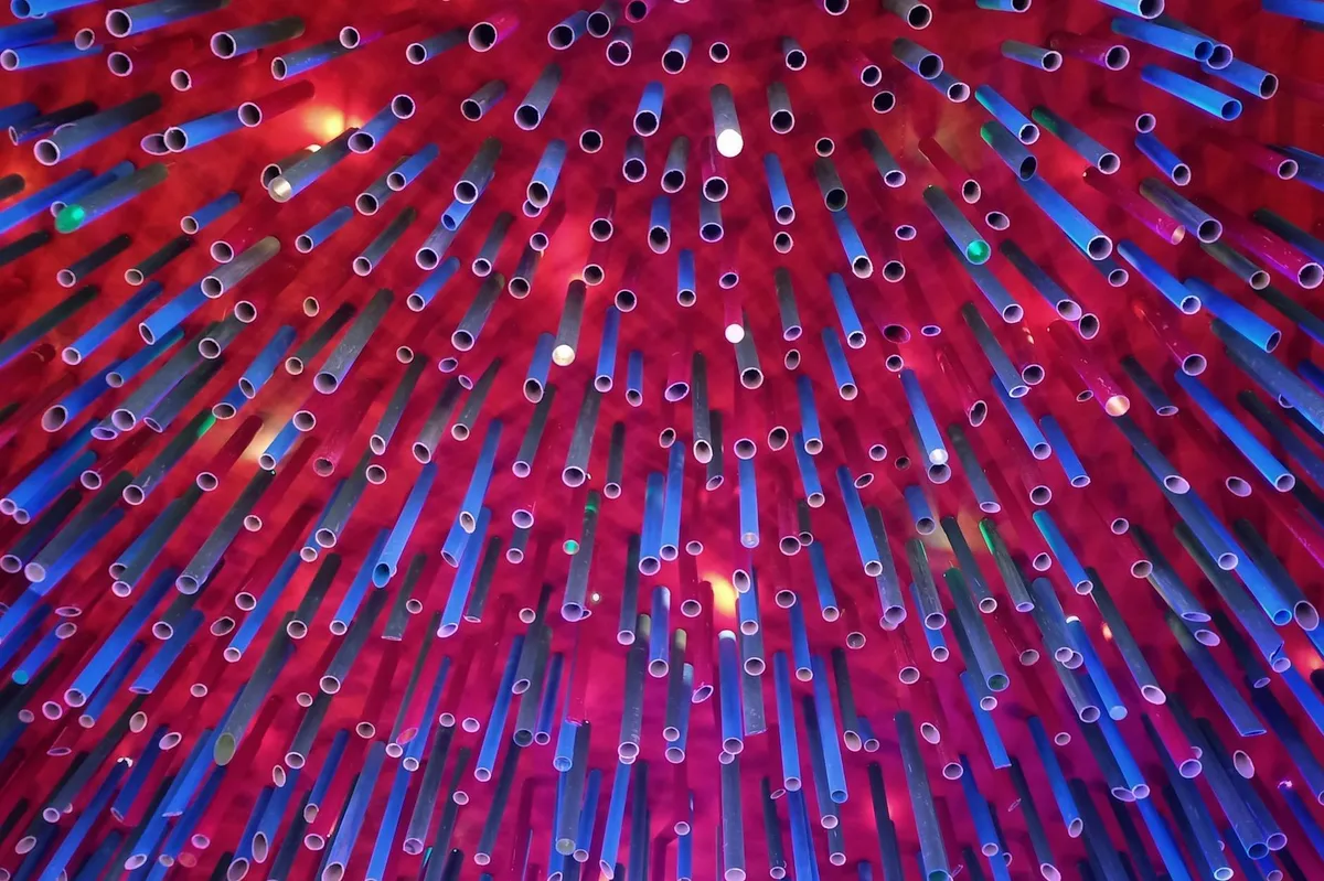 Lebendige abstrakte Installation mit bunten Rohren vor strukturiertem Hintergrund