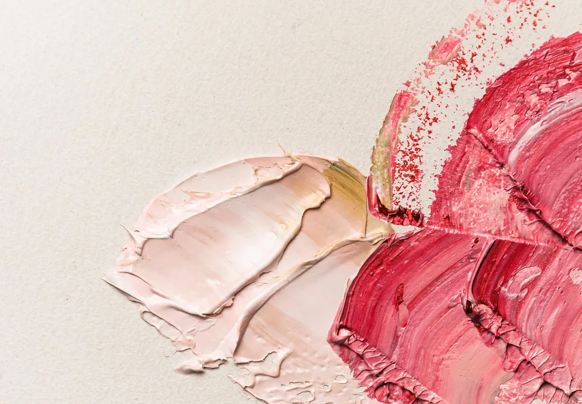 Abstract oil paint textures on canvas with vibrant red and pink tones.