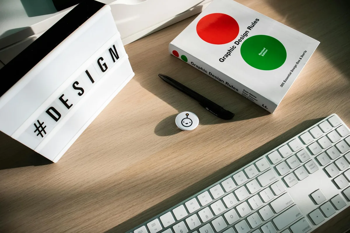 Scrivania luminosa con libro di design, tastiera e lightbox hashtag