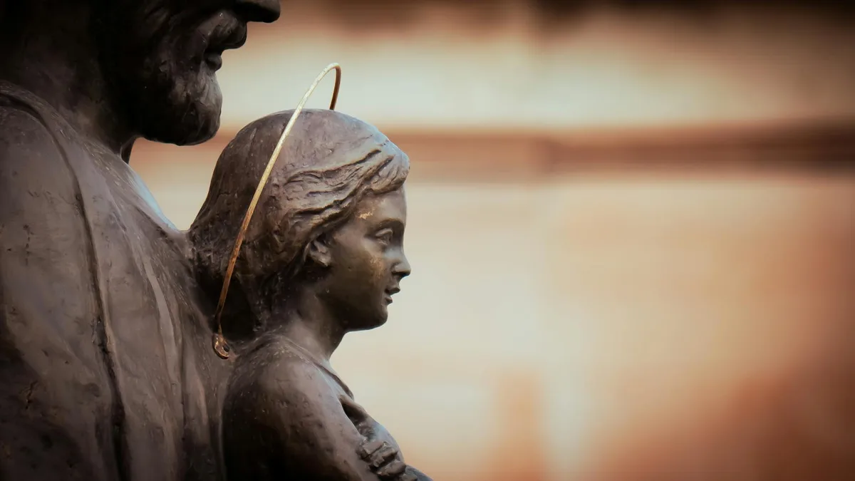 Nahaufnahme einer detaillierten Bronzeskulptur mit religiösen Figuren in nachdenklichen Posen