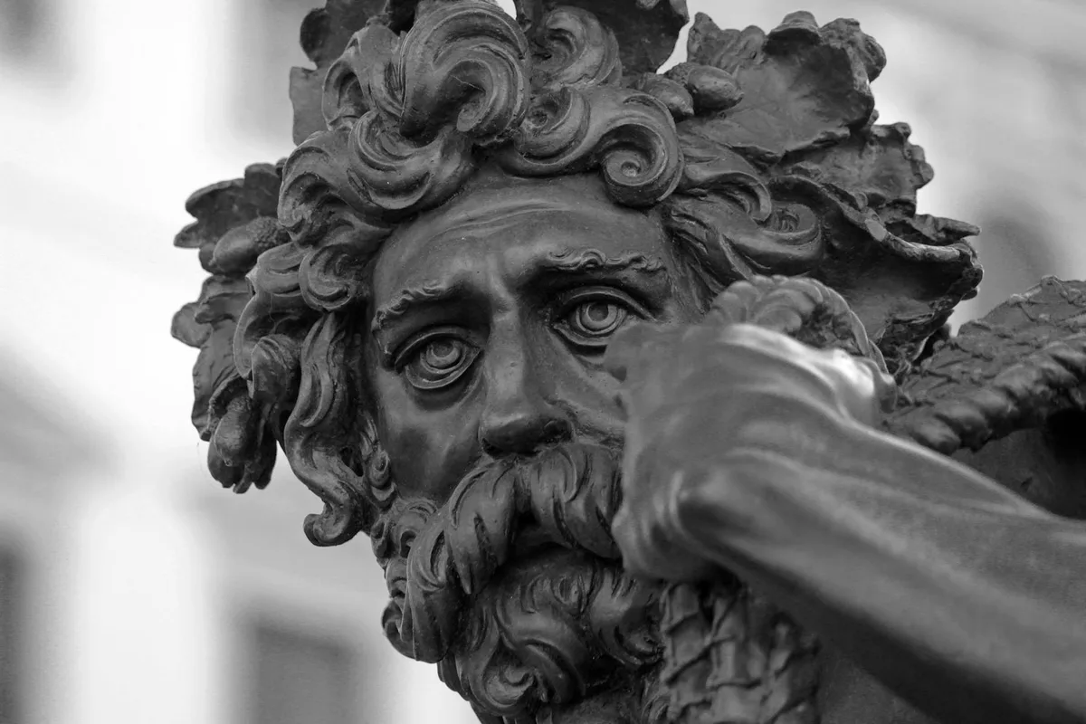 Primo piano in bianco e nero di scultura bronzea classica maschile