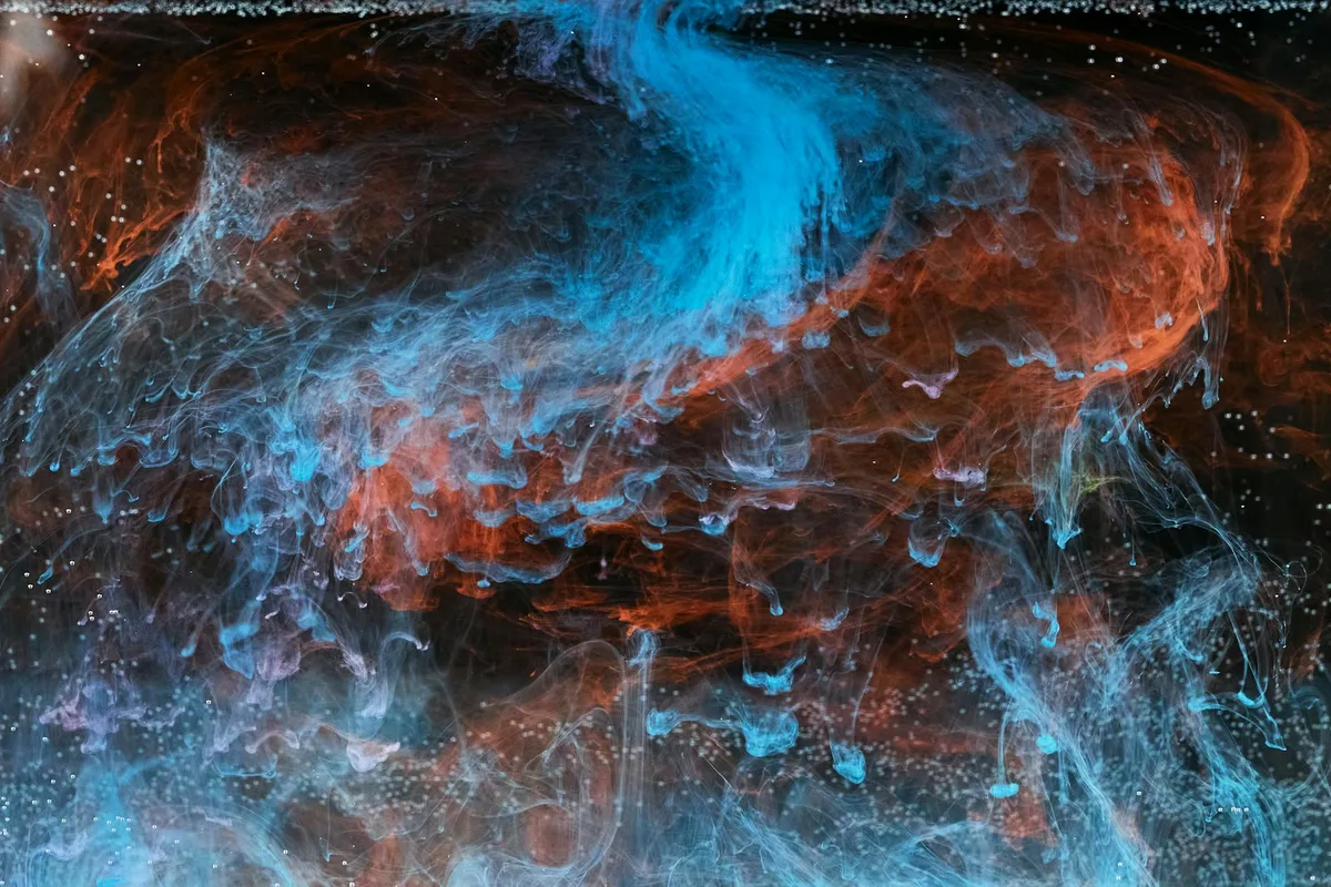 Astratto vorticoso di inchiostro blu e arancione che vortica in acqua, effetto visivo accattivante.