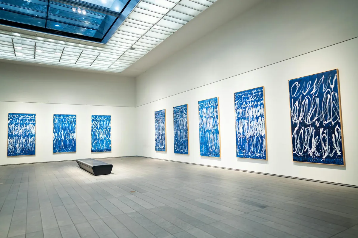 Spaziosa galleria d'arte moderna con dipinti astratti blu in esposizione