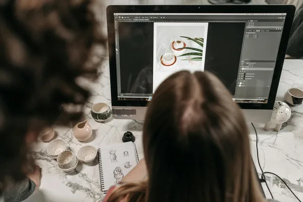 스튜디오에서 Adobe Photoshop으로 사진 편집 협업하는 두 사람